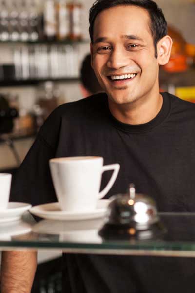 Student on laptop while holding a piece of pizza